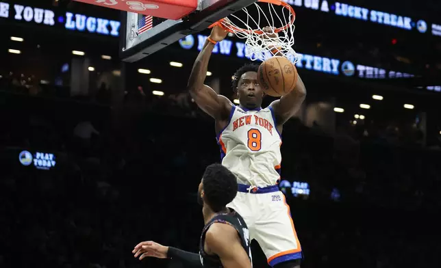 New York Knicks forward Og Anunoby (8) dunks over Brooklyn Nets forward Chaney Johnson, bottom, during the second half of an NBA basketball game, Friday, March 20, 2026, in New York. (AP Photo/Heather Khalifa)