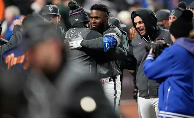 New York Mets' Luis Robert Jr. (88) celebrates with teammates after hitting a three run home run during the eleventh inning of a baseball game against the Pittsburgh Pirates, Saturday, March 28, 2026, in New York. (AP Photo/Yuki Iwamura)