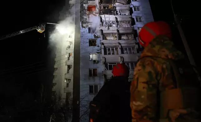 Rescue workers try to put out a fire of a residential building burning after a Russian drone attack on Zaporizhzhia, Ukraine, Tuesday, March 24, 2026. (AP Photo/Kateryna Klochko)