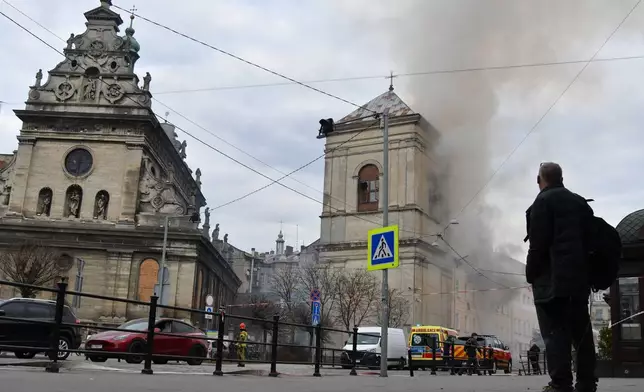 Fire and smoke raises above the city center following Russia's drone attack in Lviv, Ukraine, Tuesday, March 24, 2026. (AP Photo/Mykola Tys)
