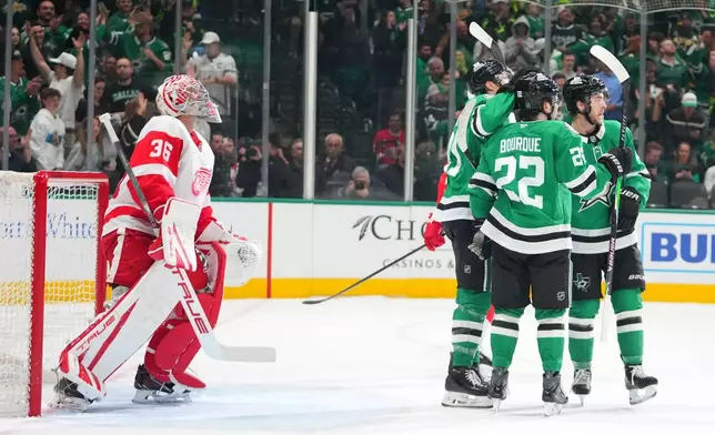 Dallas Stars center Wyatt Johnston, right, celebrates his first period goal with center Mavrik Bourque (22) and left wing Jason Robertson, center, as Detroit Red Wings goaltender John Gibson (36) looks on during an NHL hockey game Saturday, March 14, 2026, in Dallas. (AP Photo/Julio Cortez)