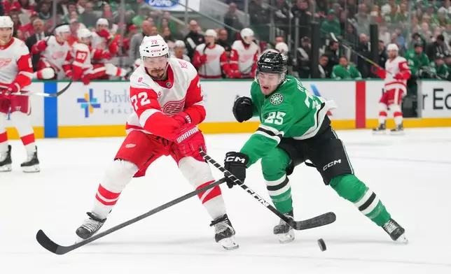 Detroit Red Wings defenseman Justin Faulk (72) and Dallas Stars right wing Arttu Hyry (25) compete for possession of the puck during the first period of an NHL hockey game Saturday, March 14, 2026, in Dallas. (AP Photo/Julio Cortez)