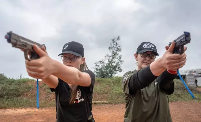 Mother and daughter Ninieve and Isabella Du Plessis, train at the Out There Sport Shooting Range in Bronkhorstspruit, Pretoria, South Africa, Saturday, Jan. 24, 2026. (AP Photo/Jacques Nelles)