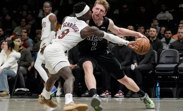Brooklyn Nets forward Danny Wolf (2) attempts to drives past Cleveland Cavaliers guard Dennis Schroder (8) during the first half of an NBA basketball game, Sunday, March 1, 2026, in New York. (AP Photo/Yuki Iwamura)