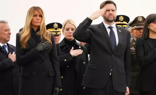 Attorney General Pam Bondi is seen standing between first lady Melania Trump and Vice President JD Vance during a casualty return for the soldiers who were killed in a drone strike at a command center in Kuwait after the U.S. and Israel launched its military campaign against Iran, Saturday, March 7, 2026, at Dover Air Force Base, Del. (AP Photo/Julia Demaree Nikhinson)