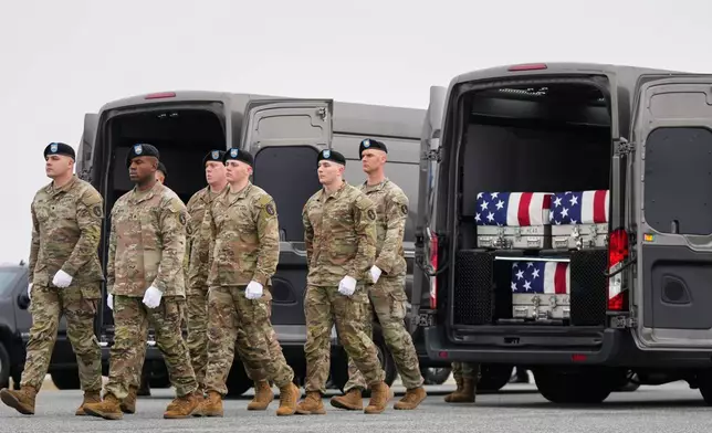 An Army carry team walk away from a transport van containing the remains of U.S. Army Reserve soldiers Maj. Jeffrey O'Brien, of Indianola, Iowa, Capt. Cody Khork, of Winter Haven, Fla., and Chief Warrant Officer 3 Robert Marzan, of Sacramento, Calif., who were killed in a drone strike at a command center in Kuwait after the U.S. and Israel launched its military campaign against Iran, during a casualty return, Saturday, March 7, 2026, at Dover Air Force Base, Del. (AP Photo/Mark Schiefelbein)