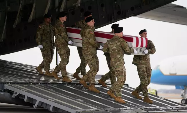 An Army carry team moves a flag-draped transfer case with the remains of Sgt. Declan Coady, 20, of West Des Moines, Iowa, who was killed in a drone strike at a command center in Kuwait after the U.S. and Israel launched its military campaign against Iran, past President Donald Trump and first lady Melania Trump during a casualty return, Saturday, March 7, 2026, at Dover Air Force Base, Del. (AP Photo/Mark Schiefelbein)