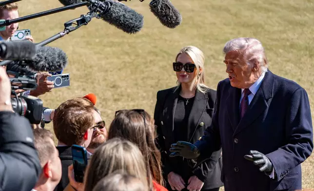 President Donald Trump, accompanied by White House press secretary Karoline Leavitt, speaks to reporters before departing on Marine One from the South Lawn of the White House, Friday, Feb. 27, 2026, in Washington. (AP Photo/Alex Brandon)
