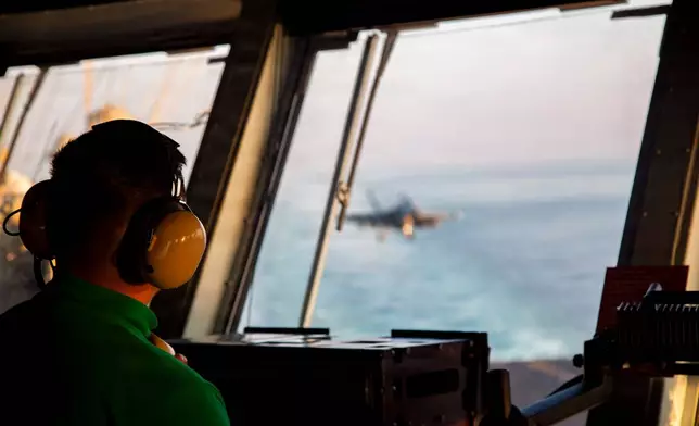 This image provided by U.S. Central Command shows a Navy sailor observing flight operations aboard the USS Abraham Lincoln (CVN 72)) in support of Operation Epic Fury, on Saturday, Feb. 28, 2026. (U.S. Navy via AP)