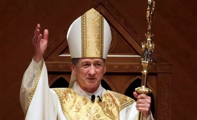 FILE - Archbishop Blase Cupich acknowledges after the retiring Cardinal Francis George presents the crozier the during his Installation Mass at Holy Name Cathedral, Nov. 18, 2014, in Chicago. (AP Photo/Charles Rex Arbogast, Pool, File)