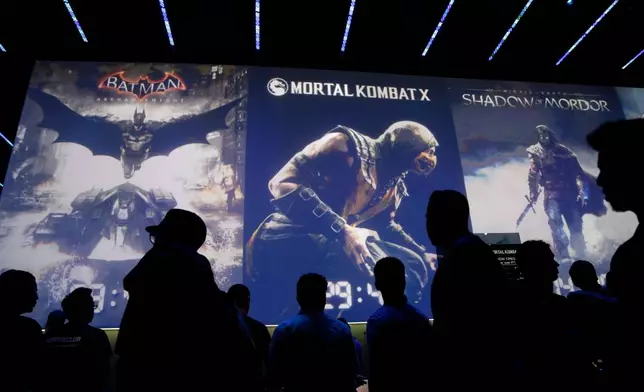 FILE - People wait in line for theater presentations for video games including Batman, Mortal Kombat X and Shadow of Mordor at the WB Games booth at the Electronic Entertainment Expo, Wednesday, June 11, 2014, in Los Angeles. (AP Photo/Jae C. Hong, File)