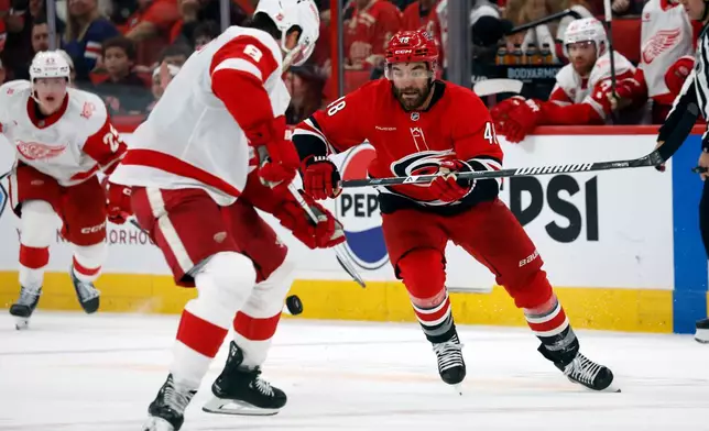 Carolina Hurricanes' Jordan Martinook (48) chases the puck toward Detroit Red Wings' Ben Chiarot (8) during the second period of an NHL hockey game in Raleigh, N.C., Saturday, Feb. 28, 2026. (AP Photo/Karl DeBlaker)