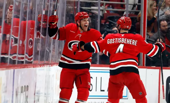 Carolina Hurricanes' Taylor Hall, left, celebrates his goal with teammate Shayne Gostisbehere (4) during the first period of an NHL hockey game against the Detroit Red Wings in Raleigh, N.C., Saturday, Feb. 28, 2026. (AP Photo/Karl DeBlaker)