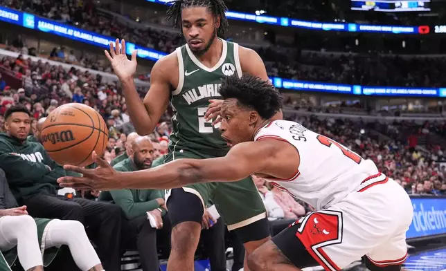 Chicago Bulls guard Collin Sexton, right, steals the ball from Milwaukee Bucks guard Cam Thomas, top, during the first half of an NBA basketball game in Chicago, Sunday, March 1, 2026. (AP Photo/Nam Y. Huh)