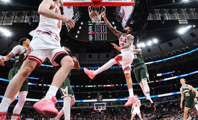 Chicago Bulls center Nick Richards (13) dunks past Milwaukee Bucks forward Kyle Kuzma (18) during the second half of an NBA basketball game in Chicago, Sunday, March 1, 2026. (AP Photo/Nam Y. Huh)