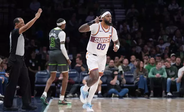 Phoenix Suns forward Royce O'Neale (00) gestures after making a 3-point shot during the first half of an NBA basketball game against the Minnesota Timberwolves, Tuesday, March 17, 2026, in Minneapolis. (AP Photo/Abbie Parr)