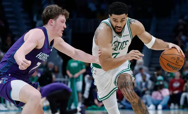 Boston Celtics forward Jayson Tatum, right, drives against Charlotte Hornets guard Kon Knueppel during the second half of an NBA basketball game in Charlotte, N.C., Sunday, March 29, 2026. (AP Photo/Nell Redmond)