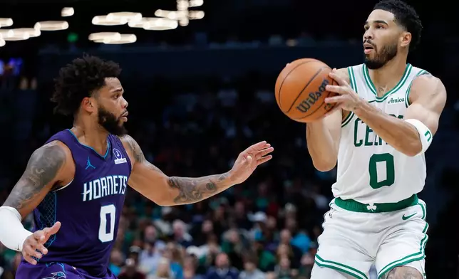 Boston Celtics forward Jayson Tatum (0) looks to shoot against Charlotte Hornets forward Miles Bridges during the second half of an NBA basketball game in Charlotte, N.C., Sunday, March 29, 2026. (AP Photo/Nell Redmond)