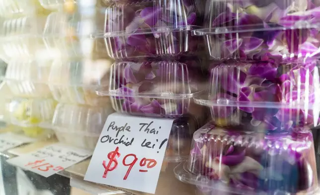 Purple Thai orchid leis sit inside a refrigerator at M.P. Lei Shop in Chinatown, Thursday, Feb. 26, 2026, in Honolulu. (AP Photo/Mengshin Lin)