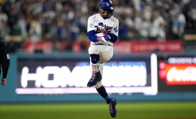 Los Angeles Dodgers' Mookie Betts celebrates after hitting a three-run home run during the third inning of a baseball game against the Arizona Diamondbacks, Friday, March 27, 2026, in Los Angeles. (AP Photo/Mark J. Terrill)