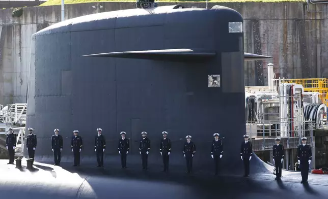 Members of the French Navy are aboard a submarine awaiting the arrival of French President Emmanuel Macron at the nuclear submarine navy base of Ile Longue in Crozon, France, Monday March 2, 2026. (Yoan Valat/Pool Photo via AP)