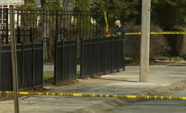 Baltimore police put up crime scene tape after an officer was shot during an active shooter incident in Northwest Baltimore, Tuesday, March 10, 2026. (WMAR-2 NEWS via AP)