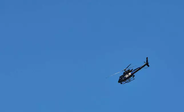 A Baltimore Police helicopter flies above the scene of a shooting Tuesday, March 10, 2026, in Baltimore. (AP Photo/KT Kanazawich)