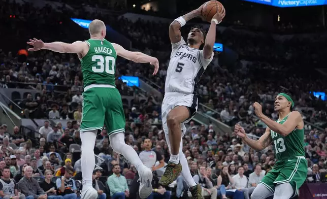 San Antonio Spurs guard Stephon Castle (5) drives to the basket against Boston Celtics forward Sam Hauser (30) during the second half of an NBA basketball game in San Antonio, Tuesday, March 10, 2026. (AP Photo/Eric Gay)