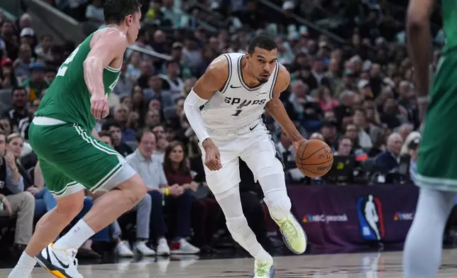 San Antonio Spurs forward Victor Wembanyama (1) drives against Boston Celtics center Luka Garza, left, during the second half of an NBA basketball game in San Antonio, Tuesday, March 10, 2026. (AP Photo/Eric Gay)