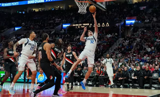 Dallas Mavericks forward Cooper Flagg (32) shoots during the first half of an NBA basketball game against the Portland Trail Blazers, Friday, March 27, 2026, in Portland, Ore. (AP Photo/Jenny Kane)