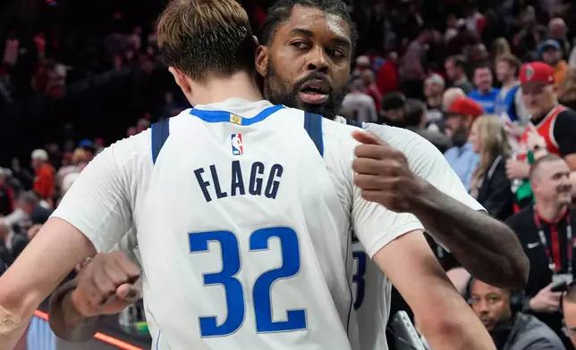 Dallas Mavericks forward Cooper Flagg (32) hugs forward Naji Marshall, right, after an NBA basketball game against the Portland Trail Blazers, Friday, March 27, 2026, in Portland, Ore. (AP Photo/Jenny Kane)