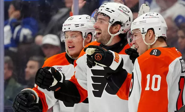 Philadelphia Flyers' Noah Cates, center, celebrates after his goal with teammates Matvei Michkov (39) and Bobby Brink (10) during third-period NHL hockey game action against the Toronto Maple Leafs in Toronto, Monday, March 2, 2026. (Frank Gunn/The Canadian Press via AP)