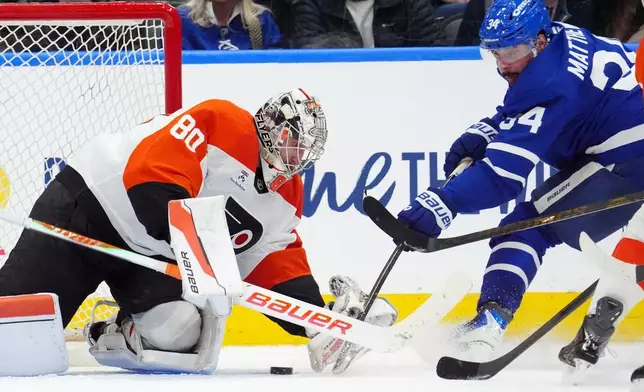 Philadelphia Flyers goaltender Dan Vladar (80) makes a save against Toronto Maple Leafs' Auston Matthews (34) during third-period NHL hockey game action in Toronto, Monday, March 2, 2026. (Frank Gunn/The Canadian Press via AP)