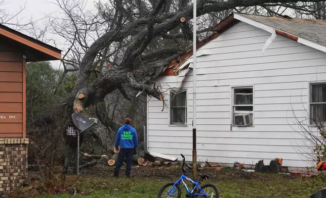Toppled trees lean against a home in the aftermath of a powerful storm that ripped through the area a day earlier in Lake Village, Ind., Wednesday, March 11, 2026. (AP Photo/Nam Y. Huh)