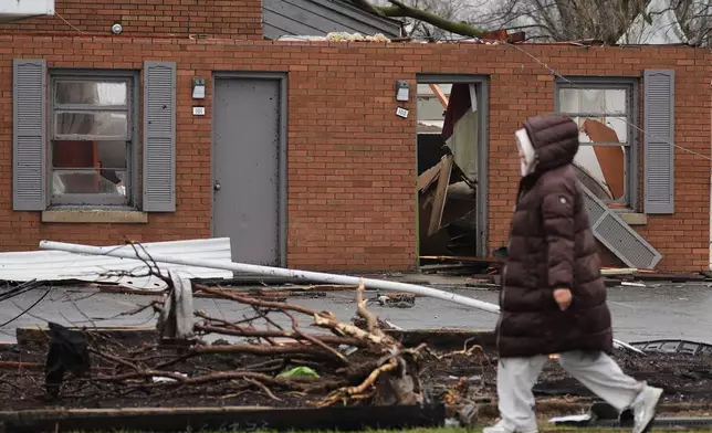 A person walks by the damage in the aftermath of a powerful storm that ripped through the area a day earlier in Kankakee, Ill., Wednesday, March 11, 2026. (AP Photo/Nam Y. Huh)