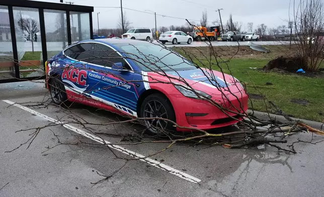 Fallen tree limbs sit in front of a vehicle as a bus stop is damaged in the aftermath of a powerful storm that ripped through the area a day earlier in Kankakee, Ill., Wednesday, March 11, 2026. (AP Photo/Nam Y. Huh)