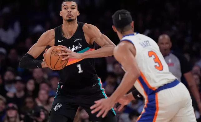San Antonio Spurs' Victor Wembanyama, left, looks to pass around New York Knicks' Josh Hart (3) during the second half of an NBA basketball game Sunday, March 1, 2026, in New York. (AP Photo/Seth Wenig)