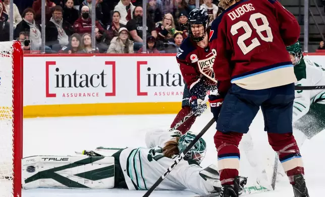 Montreal Victoire's Laura Stacey (7) and Catherine Dubois (28) watch as the puck shot by teammate Victoire's Abby Roque (not shown) sails past Boston Fleet goaltender Aerin Frankel, left, during second-period PWHL hockey game action in Laval, Quebec, Sunday March 15, 2026. (Peter McCabe/The Canadian Press via AP)