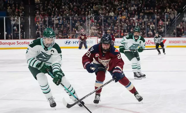 Boston Fleet's Megan Keller (5) skates in to take the puck from Montreal Victoire's Maureen Murphy (21) during second-period PWHL hockey game action in Laval, Quebec, Sunday March 15, 2026. (Peter McCabe/The Canadian Press via AP)