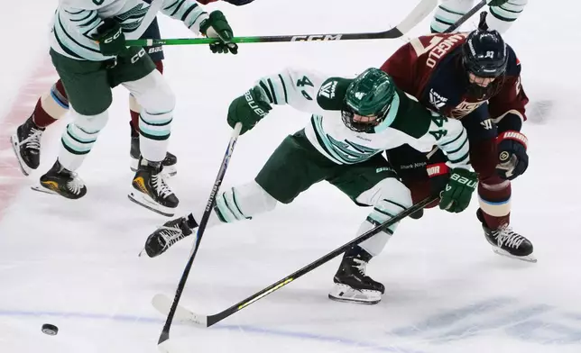Boston Fleet's Jill Saulnier (44) fights off Montreal Victoire's Shiann Darkangelo (27) to keep possession of the puck during first-period PWHL hockey game action against the Boston Fleet in Laval, Quebec, Sunday March 15, 2026. (Peter McCabe/The Canadian Press via AP)