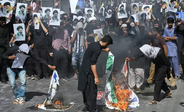 Shiite Muslims burn representation of U.S. Indian and Israeli flags during a procession, in Karachi, Pakistan, Wednesday, March 11, 2026. (AP Photo/Ali Raza)