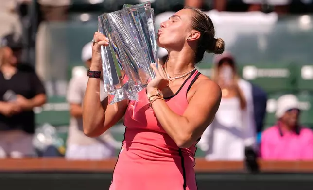Aryna Sabalenka, of Belarus, kisses the winner's trophy after defeating Elena Rybakina, of Kazakhstan, to win the BNP Paribas Open tennis tournament Sunday, March 15, 2026, in Indian Wells, Calif. (AP Photo/Mark J. Terrill)