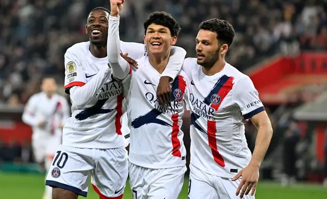 PSG's Pedro Fernandez, center, celebrates after scoring his side's third goal during the French League One soccer match between Nice and Paris Saint-Germain in Nice, France, Saturday, March 21, 2026. (AP Photo/Philippe Magoni)