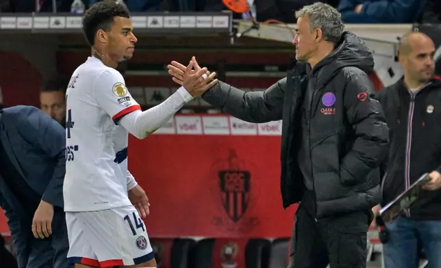 PSG's head coach Luis Enrique greets PSG's Desire Doue during the French League One soccer match between Nice and Paris Saint-Germain in Nice, France, Saturday, March 21, 2026. (AP Photo/Philippe Magoni)