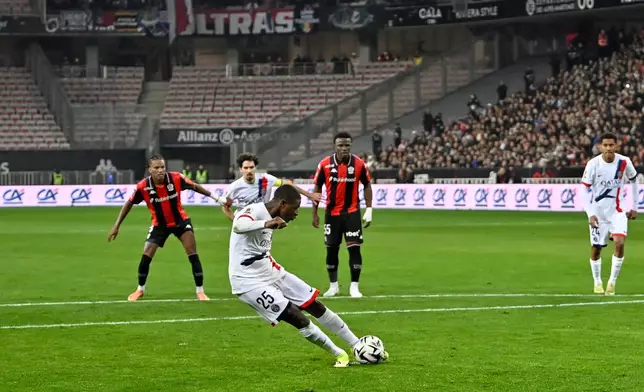 PSG's Nuno Mendes scores the opening goal from the penalty spot during the French League One soccer match between Nice and Paris Saint-Germain in Nice, France, Saturday, March 21, 2026. (AP Photo/Philippe Magoni)