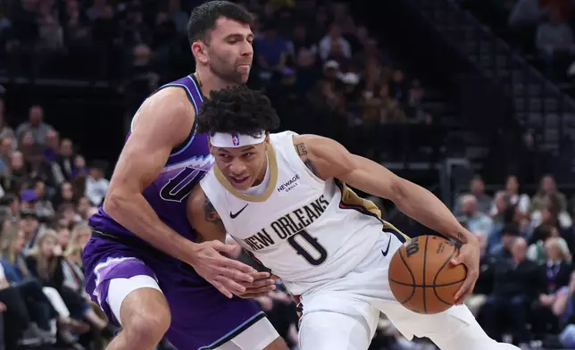 New Orleans Pelicans guard Jeremiah Fears (0) drives with the ball against Utah Jazz guard John Konchar, left, during the first half of an NBA basketball game, Saturday, Feb. 28, 2026, in Salt Lake City. (AP Photo/Rob Gray)
