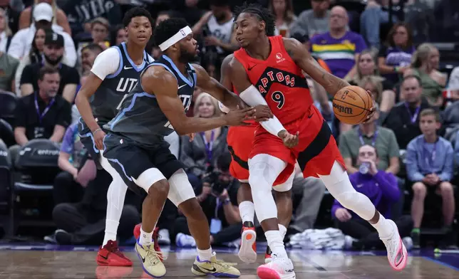 Toronto Raptors forward RJ Barrett (9) moves the ball as Utah Jazz guard Elijah Harkless, left, defends during the first half of an NBA basketball game, Monday, March 23, 2026, in Salt Lake City. (AP Photo/Rob Gray)