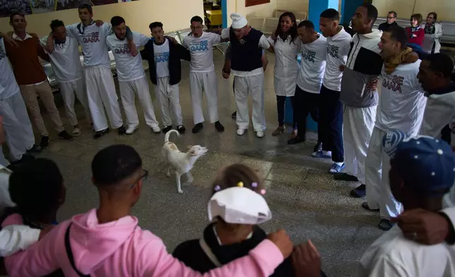 People undergoing rehabilitation hug in a circle at a psychiatric hospital in Havana, Cuba, Wednesday, Feb. 25, 2026. (AP Photo/Ramon Espinosa)