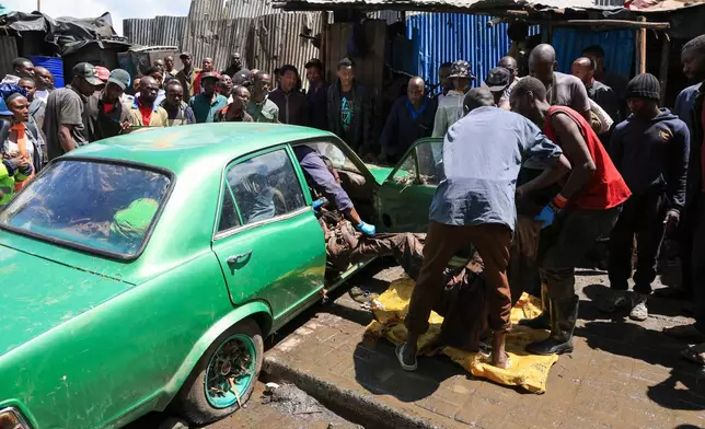 Volunteers retrieve the body of a man from a car after heavy rains in Nairobi, Kenya, Saturday, March 7, 2026. (AP Photo/Andrew Kasuku)