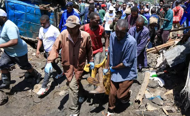 Volunteers carry the body of a man recovered after heavy rains in Nairobi, Kenya, Saturday, March 7, 2026. (AP Photo/Andrew Kasuku)
